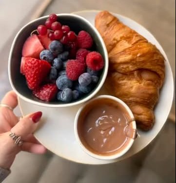 Croissant, fresh berries and chocolate on a plate
